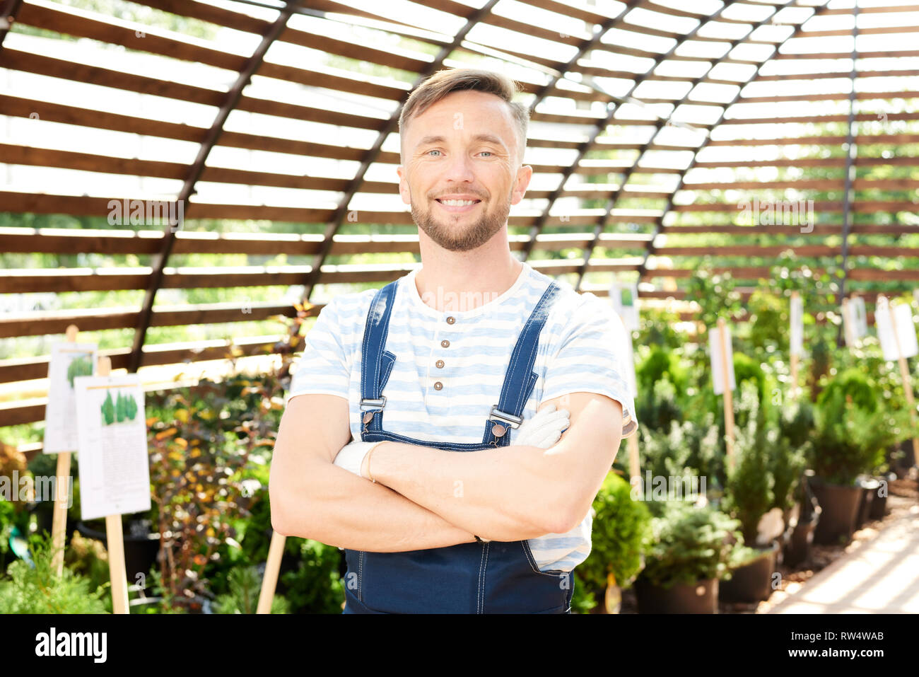 Smiling Worker Posing in Garden Stock Photo