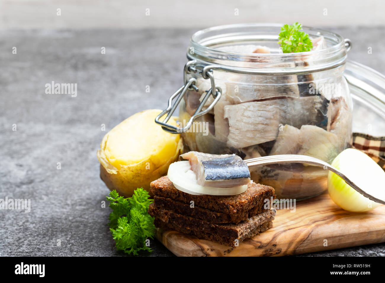 Homemade marinated herring in glass jar with rye bread and jacket