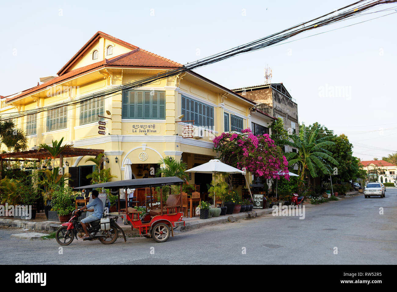 Street scene, old yellow french colonial architecture buildings in kampot downtown street and a tuk tuk cambodia Stock Photo