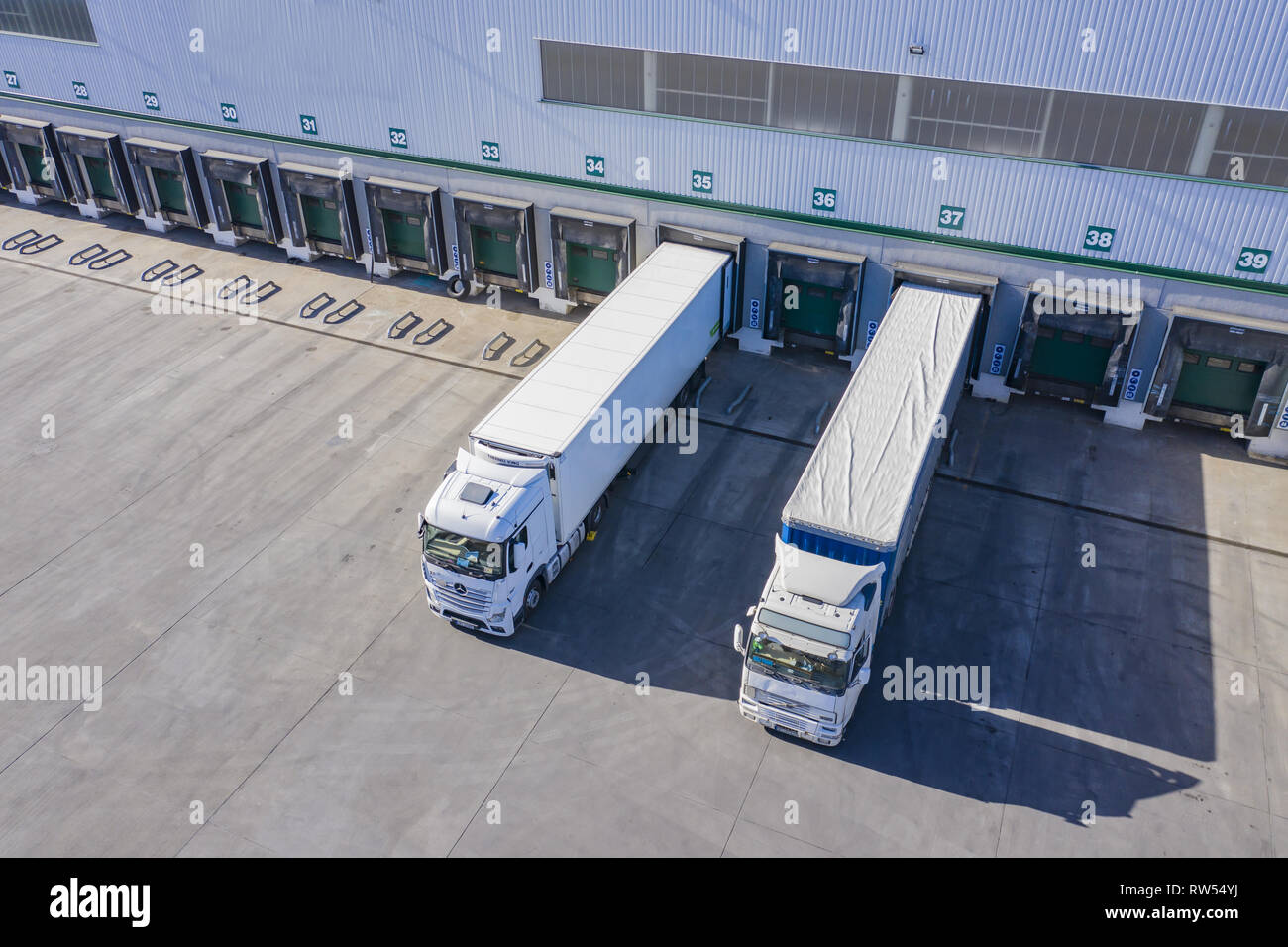Top view at a Big distribution warehouse with gates for loads and trucks. Aerial  View Stock Photo - Alamy