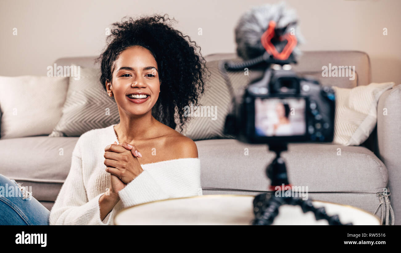 Happy female vlogger live streaming from living room using dslr camera  Stock Photo - Alamy