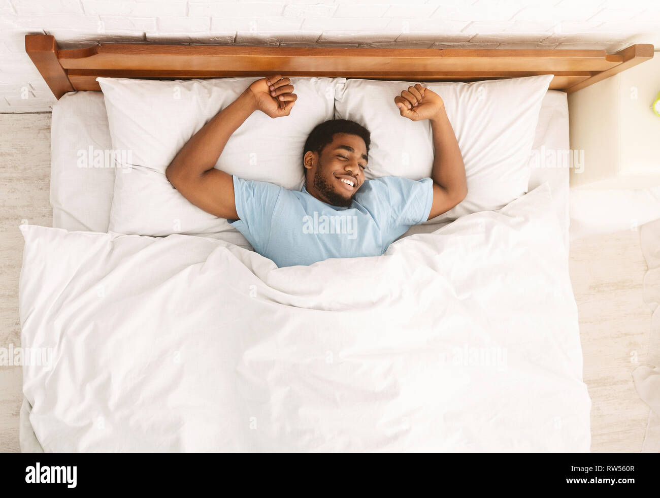 Young african-american man sleeping in bed top view Stock Photo - Alamy