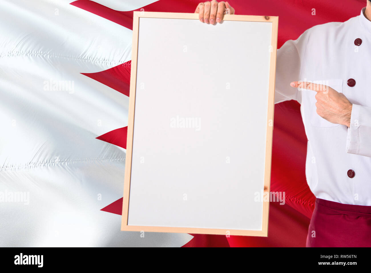 Bahraini Chef holding blank whiteboard menu on Bahrain flag background