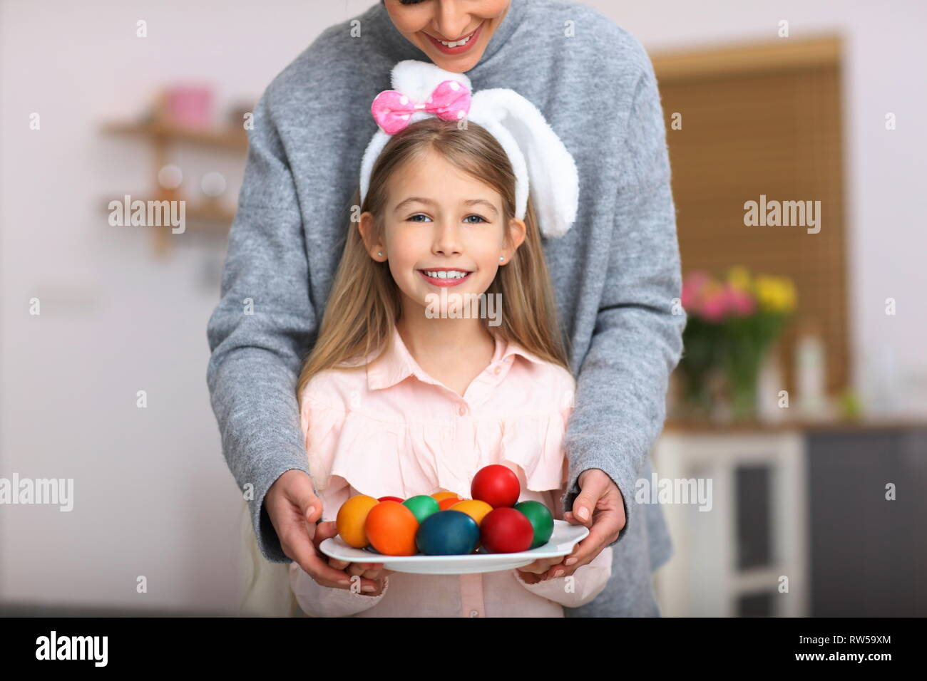 Mother and daughter painting Easter eggs at home Stock Photo