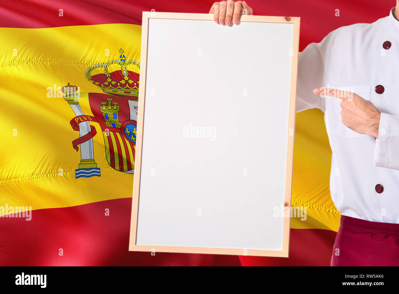 Spanish Chef holding blank whiteboard menu on Spain flag background