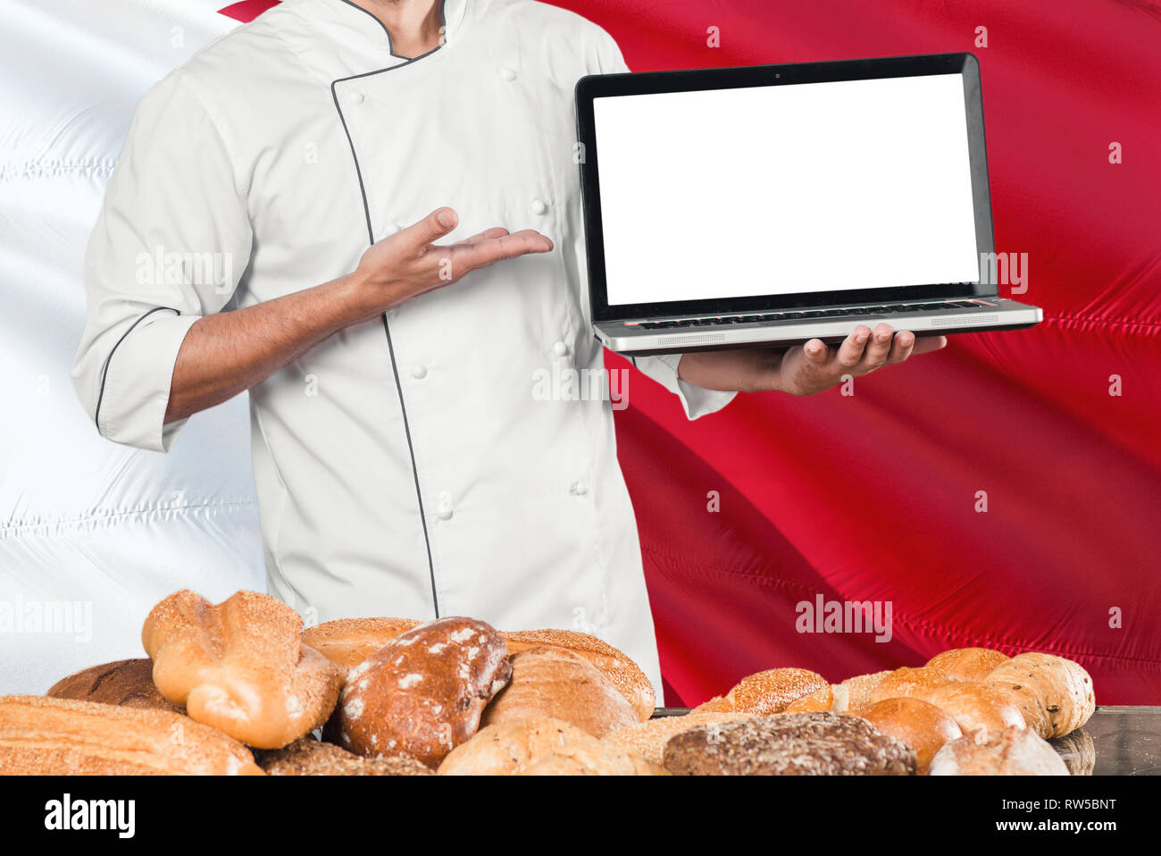 Bahraini Baker holding laptop on Bahrain flag and breads background