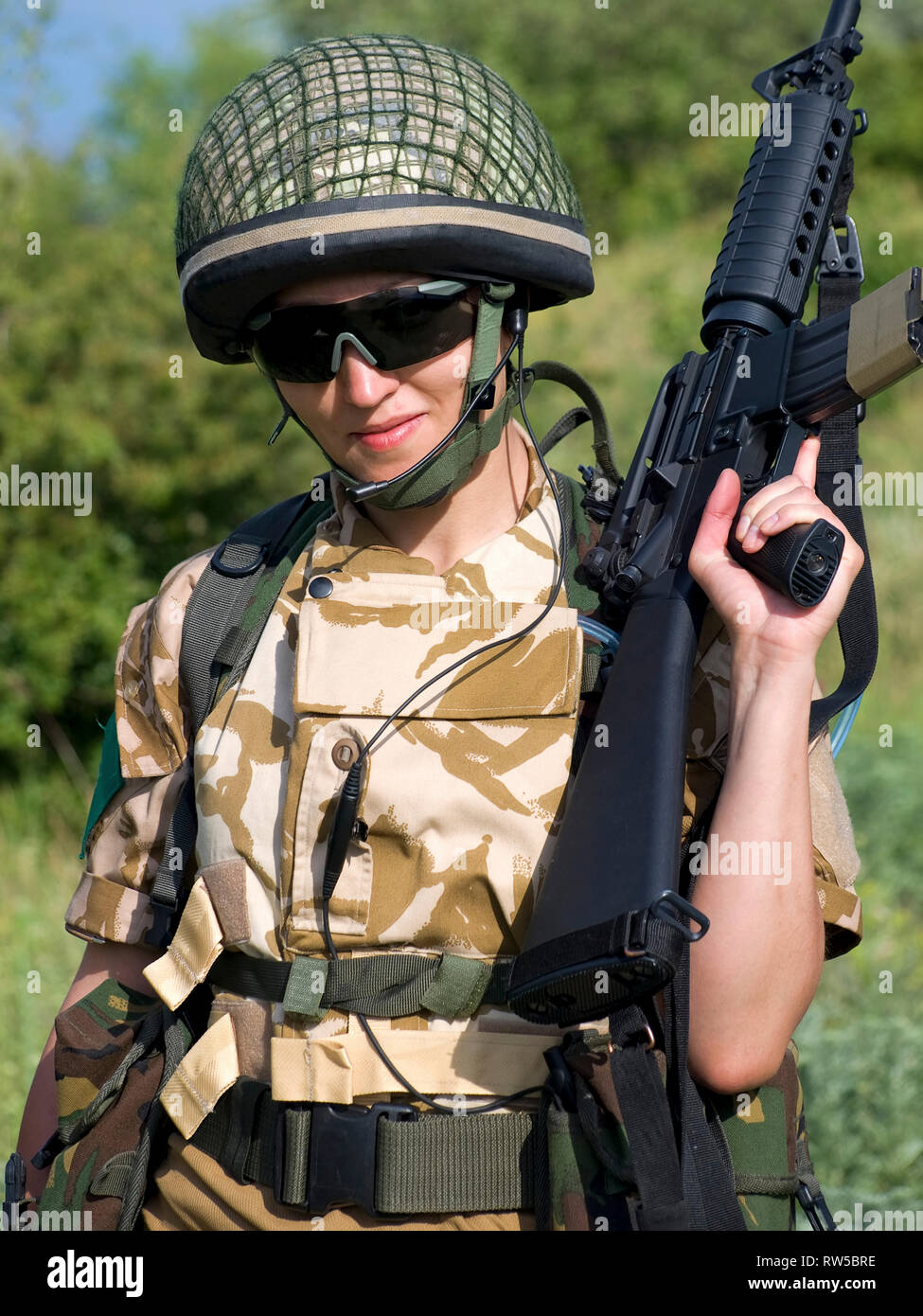 Female British soldier in desert uniform holding her rifle. Stock Photo