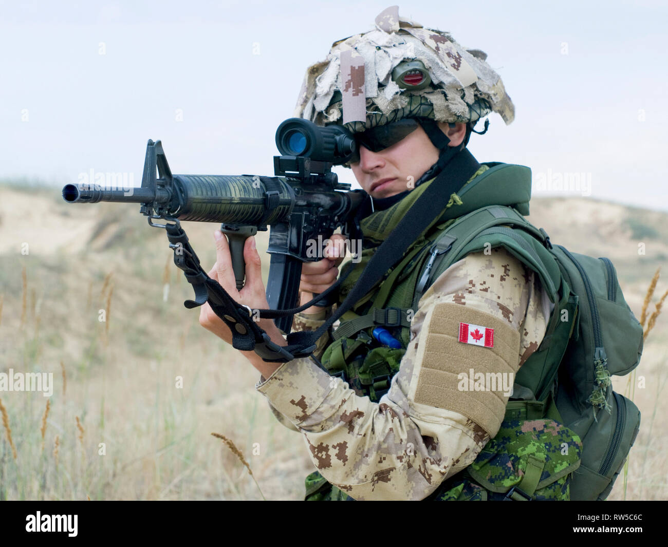 Soldier in desert uniform aiming his rifle. Stock Photo