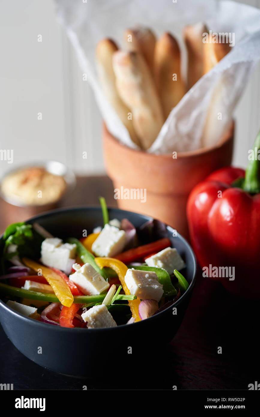 Shallow depth of field shot of plated food. Healthy Greek salad with cheese and brightly coloured peppers. Stock Photo