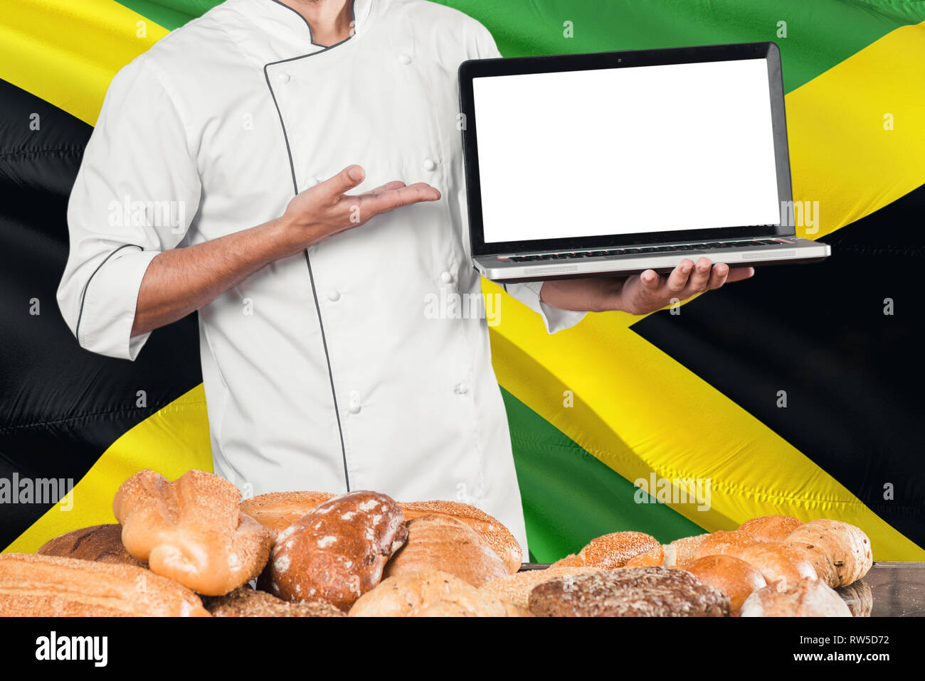 Jamaican Baker holding laptop on Jamaica flag and breads background
