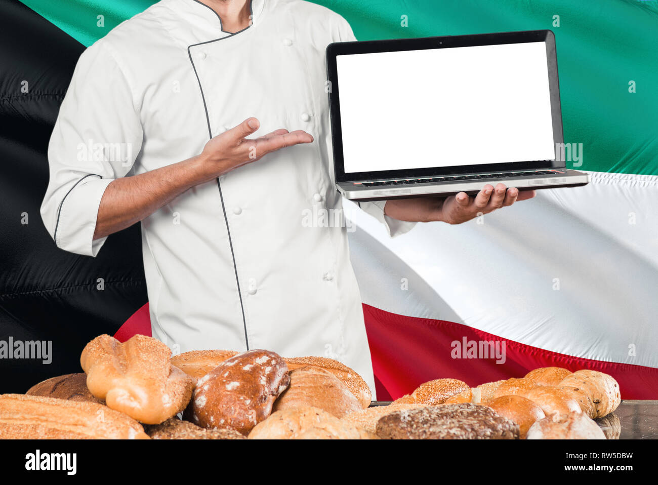Kuwaiti Baker holding laptop on Kuwait flag and breads background. Chef