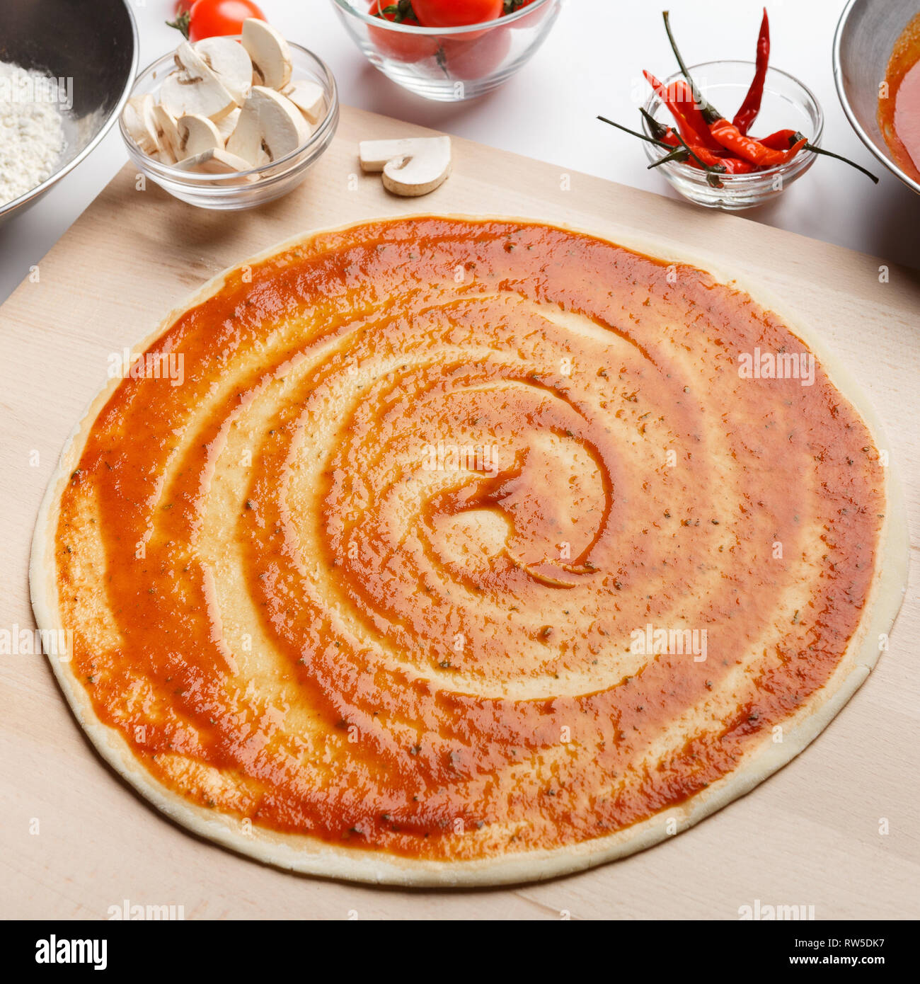 Pizza base with tomato sauce, process of preparing Stock Photo Alamy