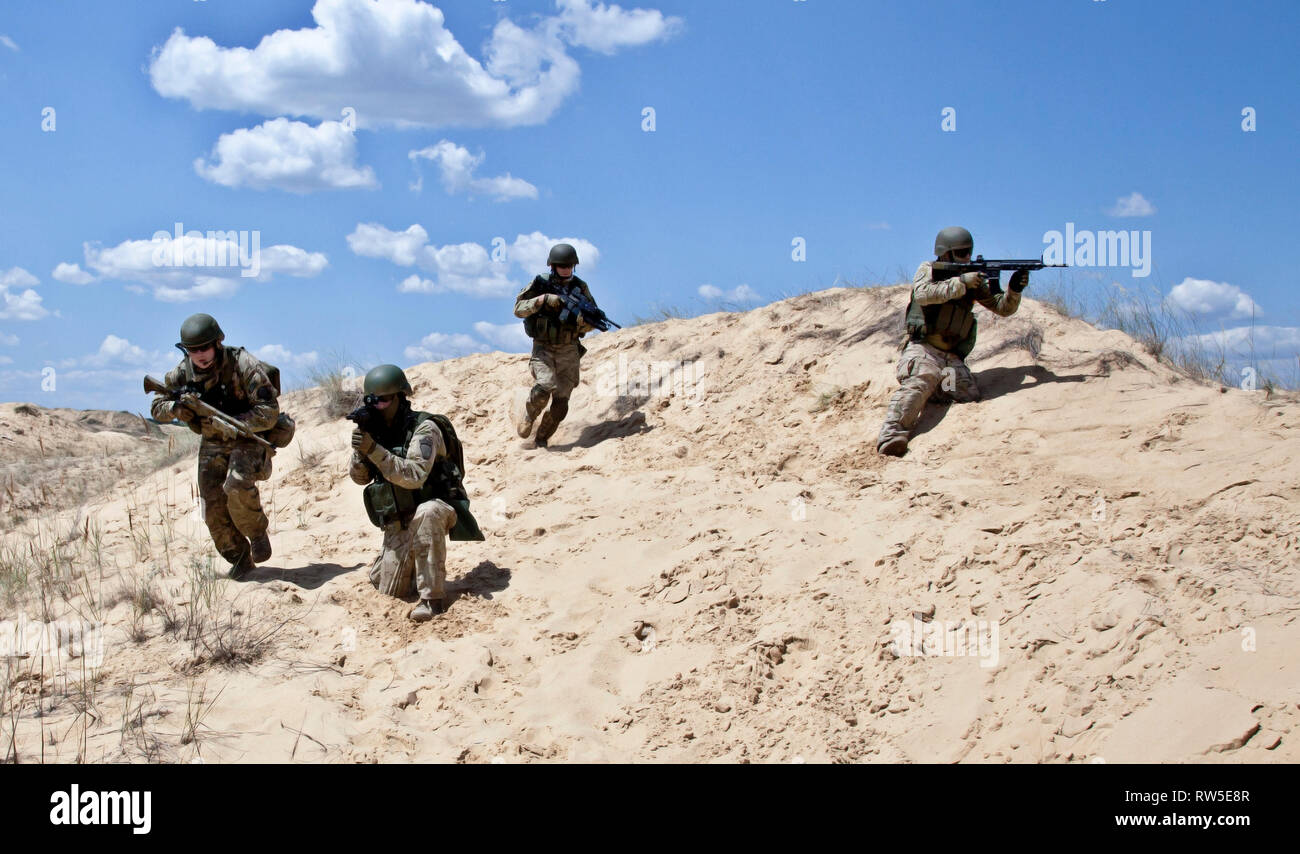 Squad of soldiers run through the desert through the military operation ...