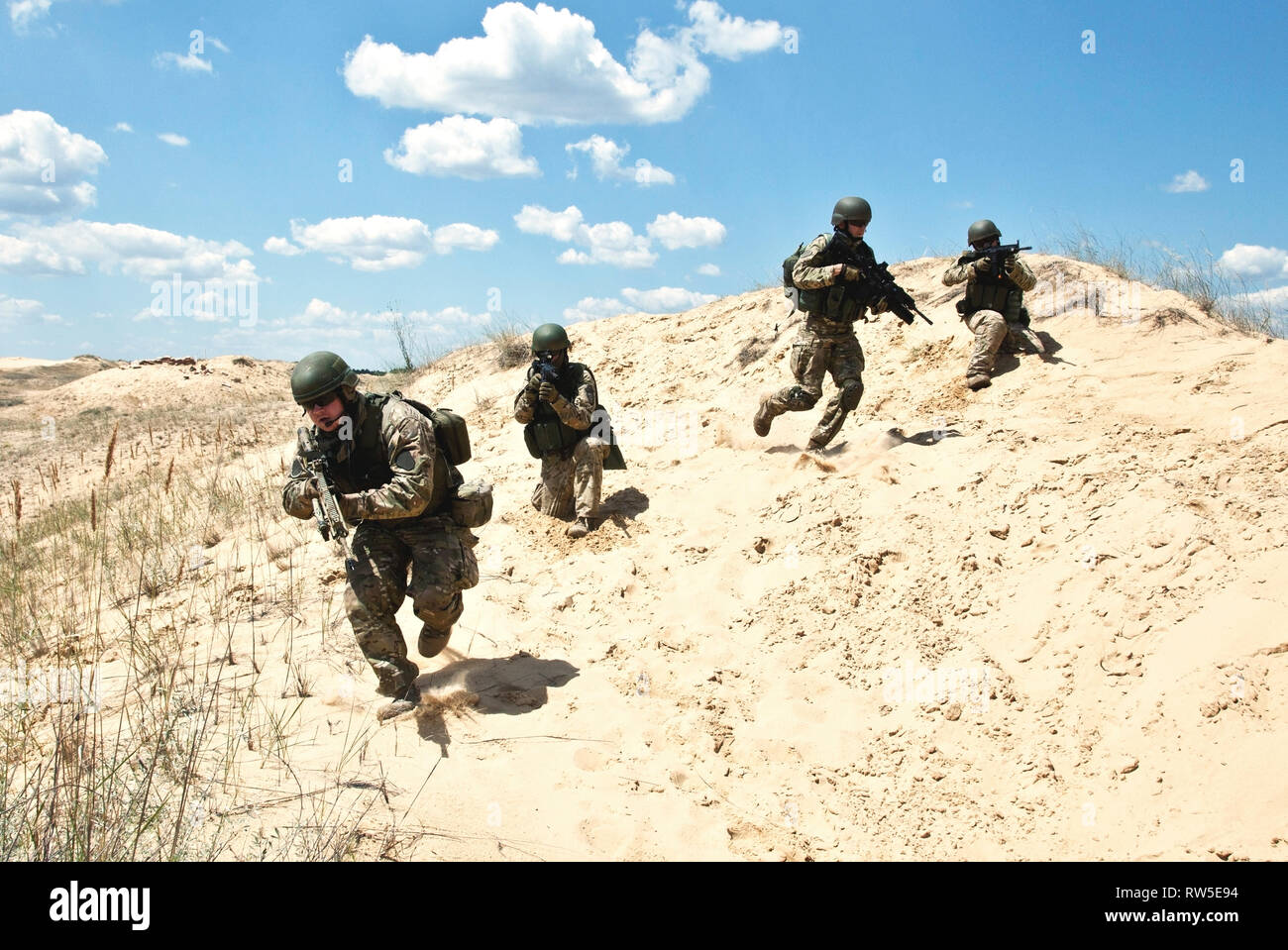 Squad of soldiers run through the desert through the military operation ...