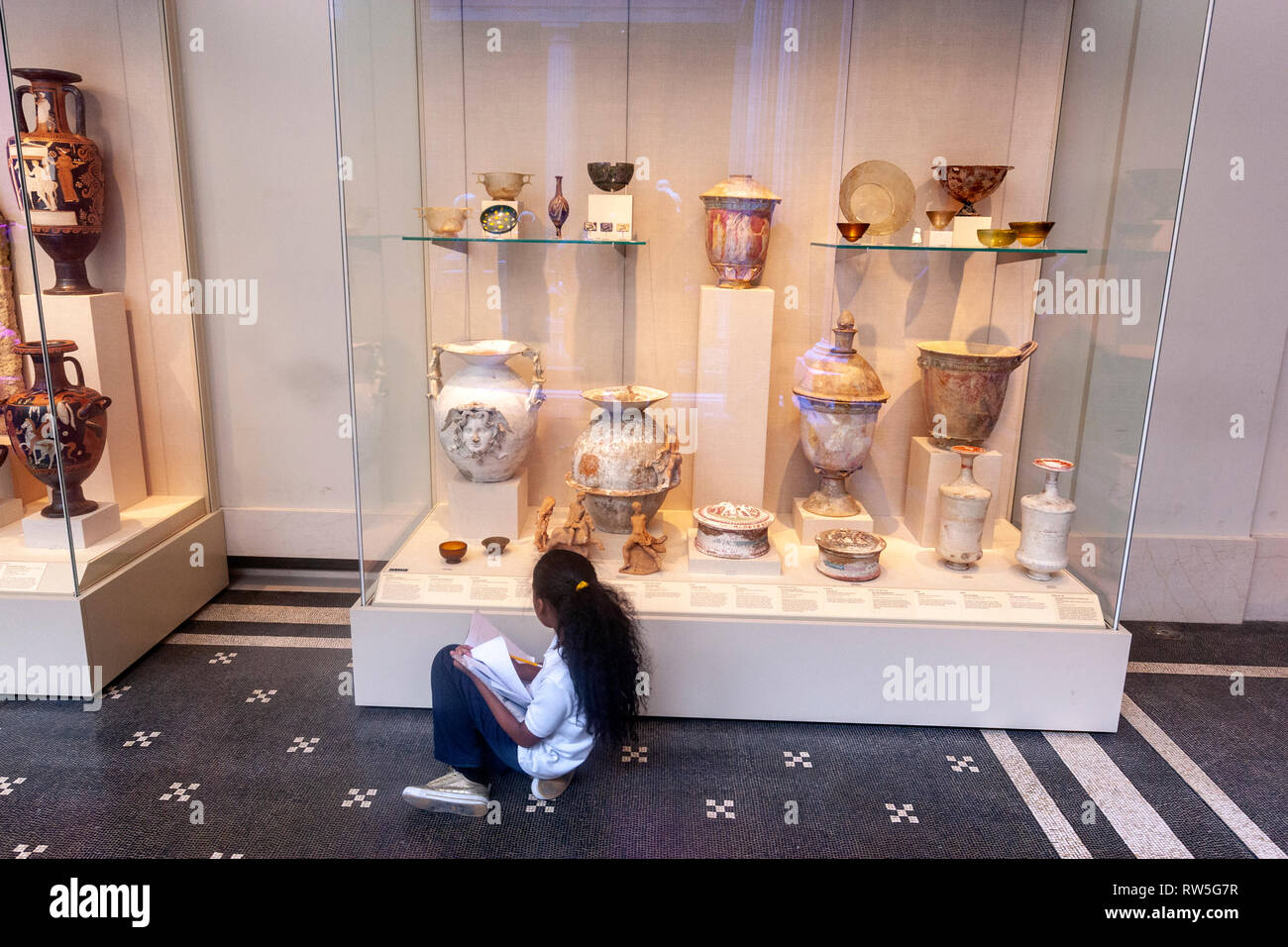 Girl taking notes in theThe Robert and Renée Belfer Court for early Greek and prehistoric art, The Metropolitan Museum of Art, Manhattan, New York USA Stock Photo