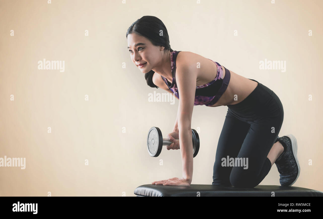 Strong Asian skinny woman is lifting dumbbell in fitness Stock Photo - Alamy