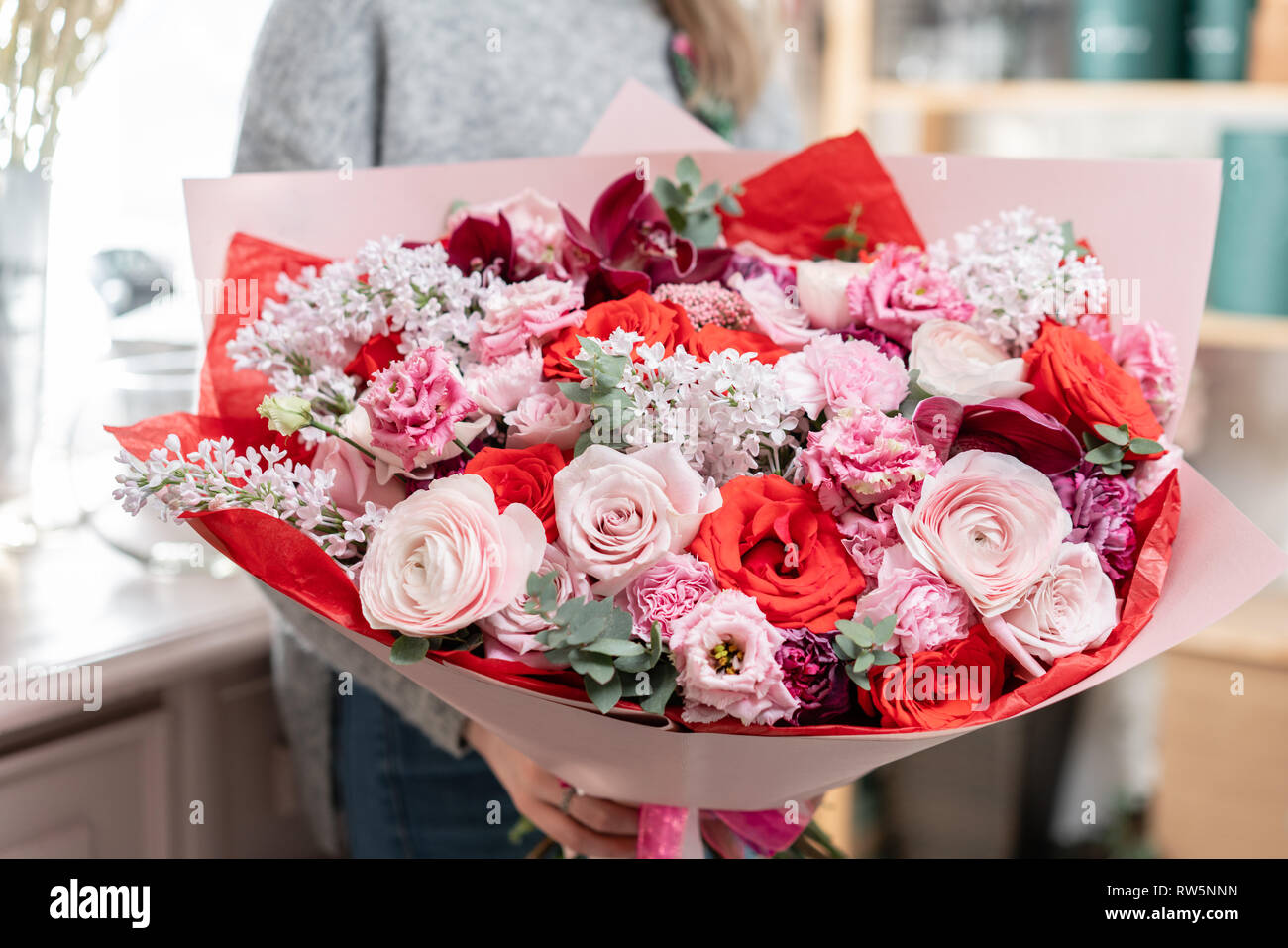 beautiful fresh cut bouquet of mixed flowers in woman hand. the work of