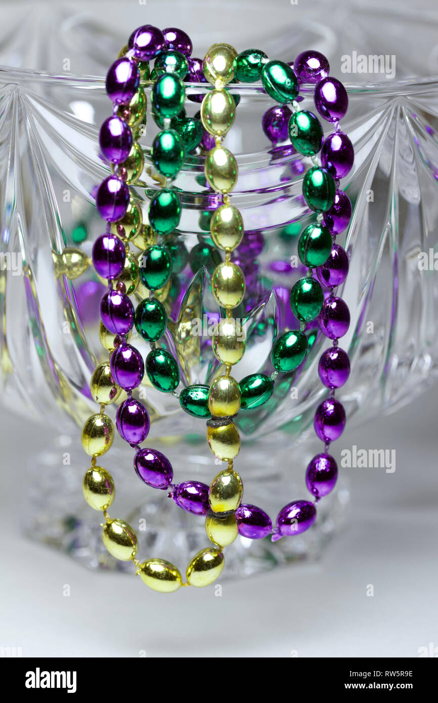 Macro abstract of traditional three color Mardi Gras beads draped over