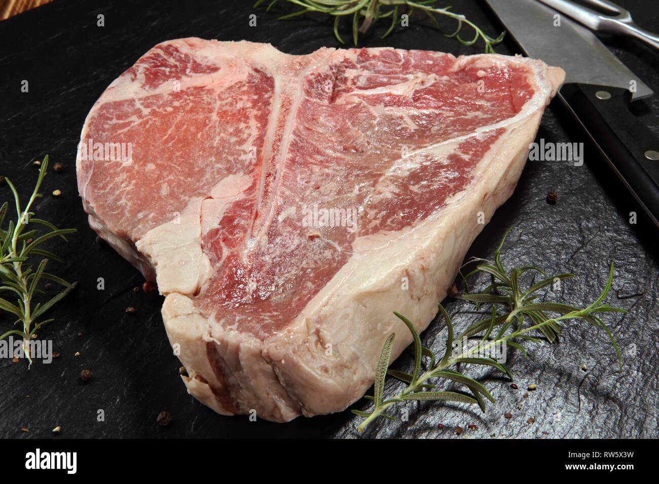 Raw Tbone steak on stone plate. bbq bone steak set Stock Photo Alamy