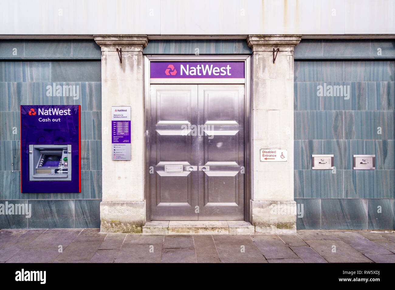 Stainless steel doors and ATM cash machine at the entrance to a branch of the NatWest bank Stock Photo