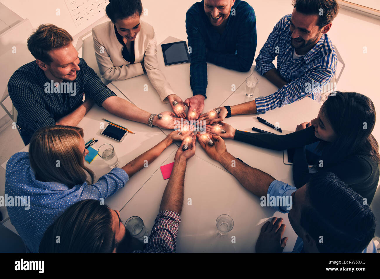 Teamwork and brainstorming concept with businessmen that share an idea with a lamp. Concept of startup Stock Photo