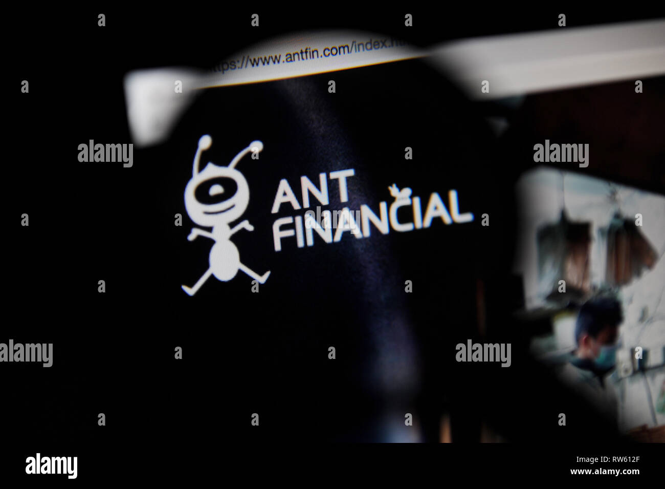 The Ant Financial website seen through a magnifying glass Stock Photo
