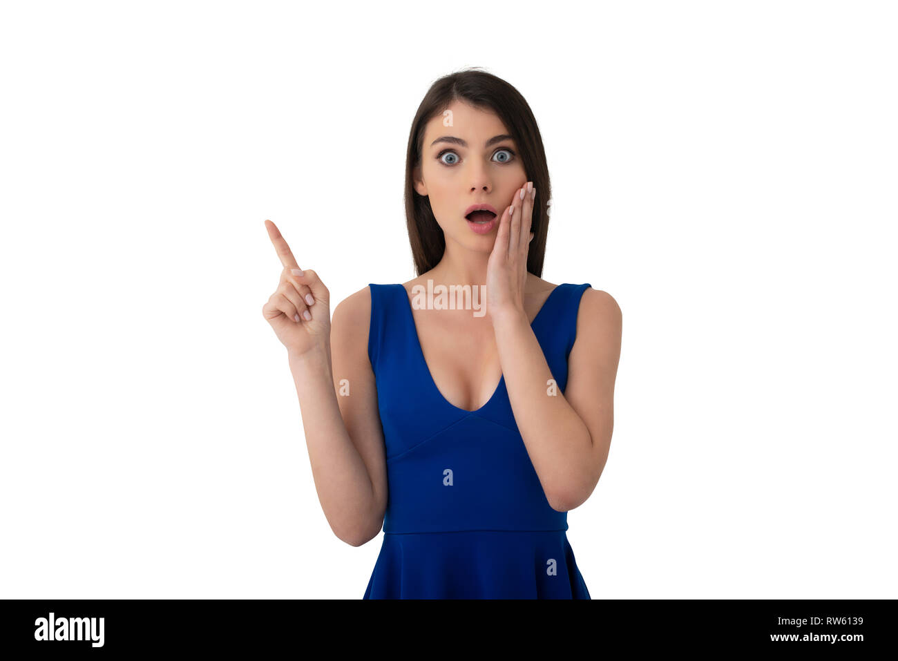 Surprised girl indicates a blank space for your text. Isolated on white background Stock Photo