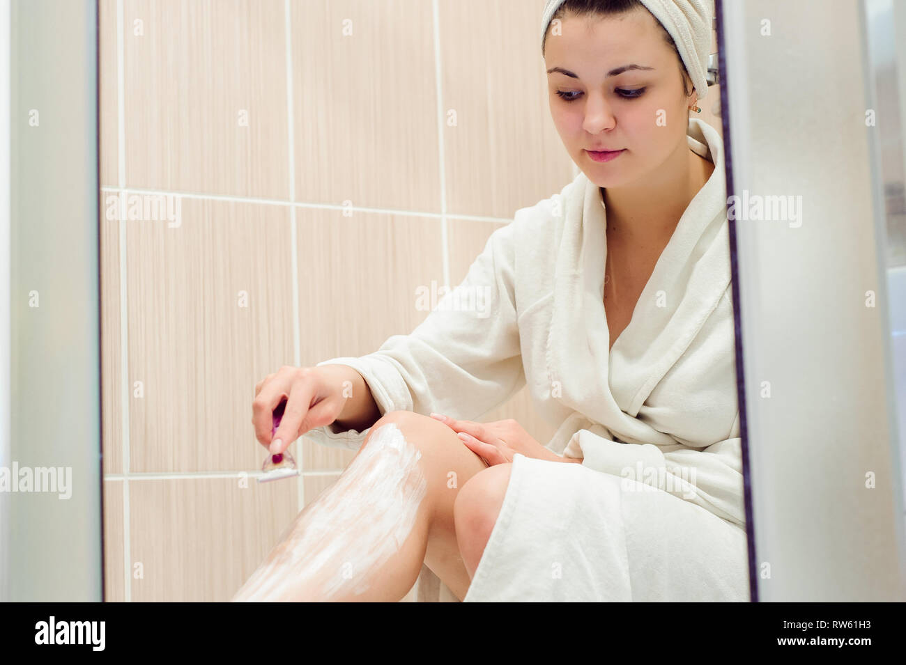 Beautiful Girl Shaving Her Legs Using A Razor While Taking Shower