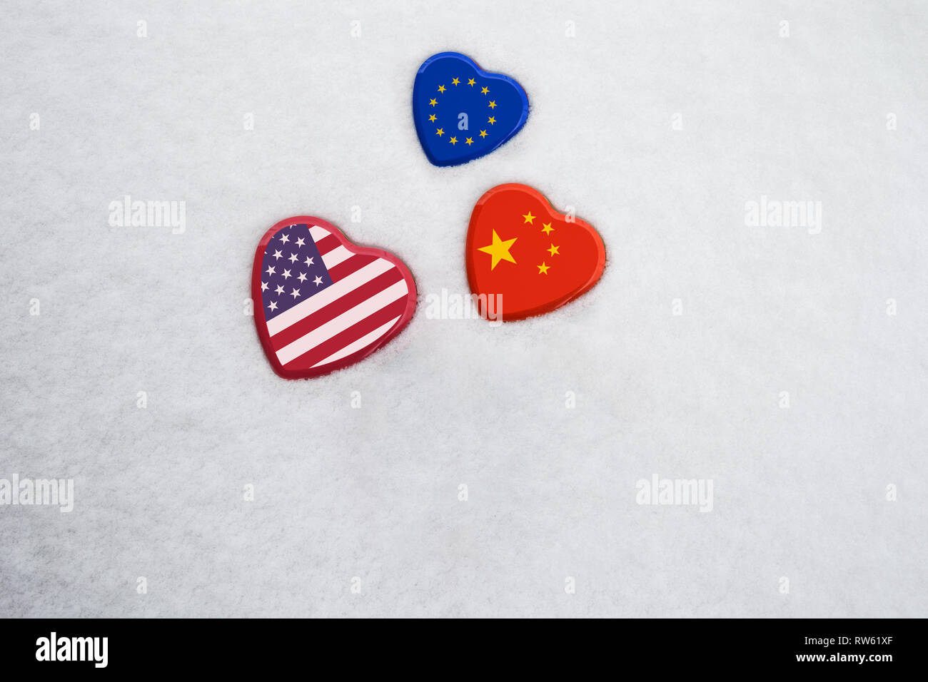 USA, China, EU national flags on heart shaped boxes laying on snow close together. Concept of economic political relationships and partnerships Stock Photo