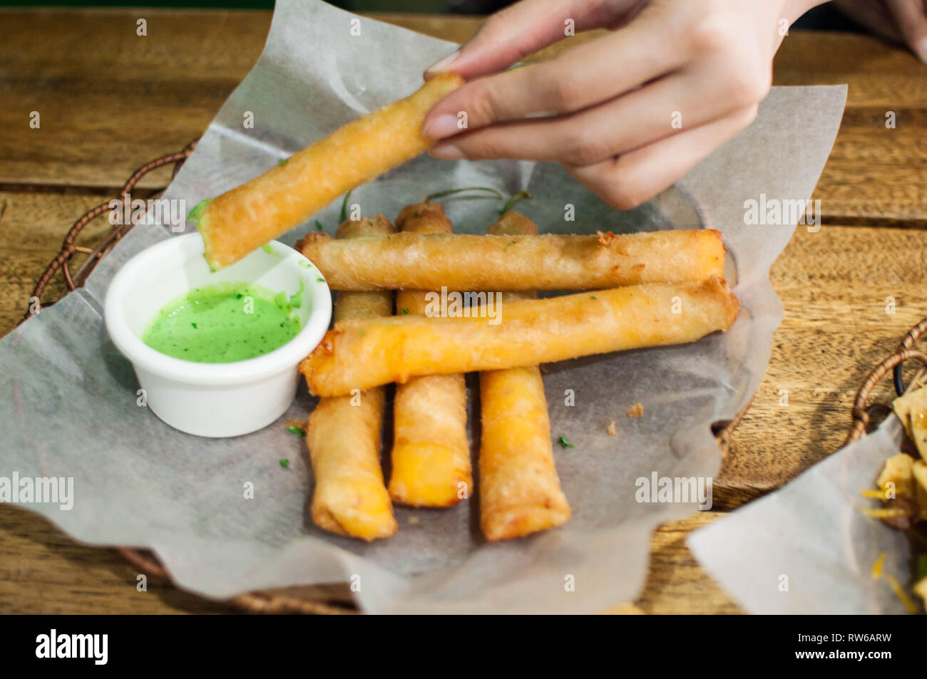 Eating a fried green chilli peppers also known as dynamite sticks Stock