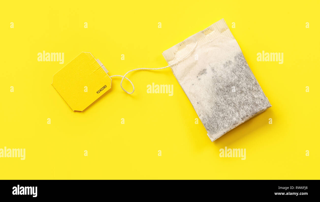 Top view, tea bag with empty label on yellow board. Stock Photo