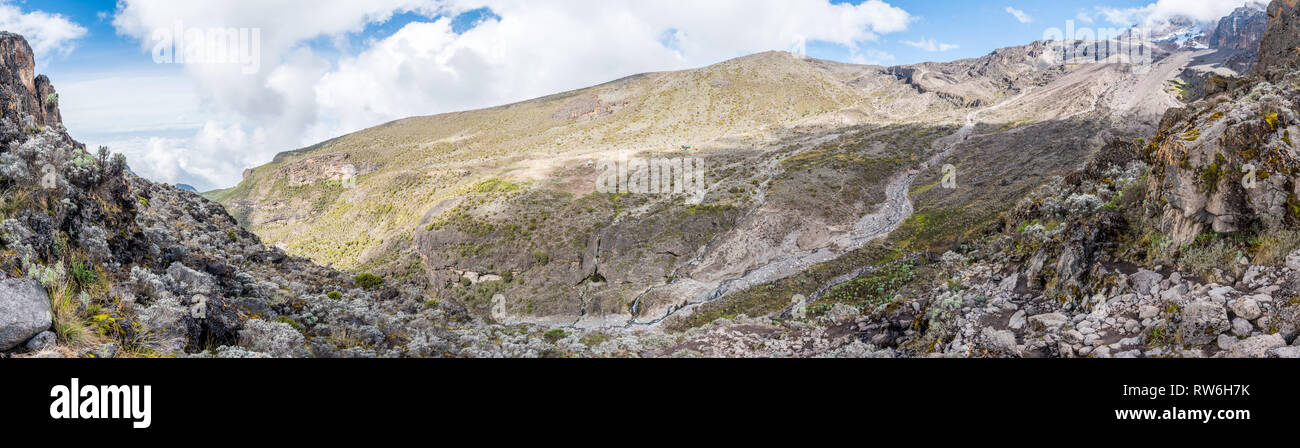 Panoramic view taken from the Barranco Wall overlooking the Baranco camp and its surrounding valley on the Machame hiking route of Mount Kilimanjaro. Stock Photo