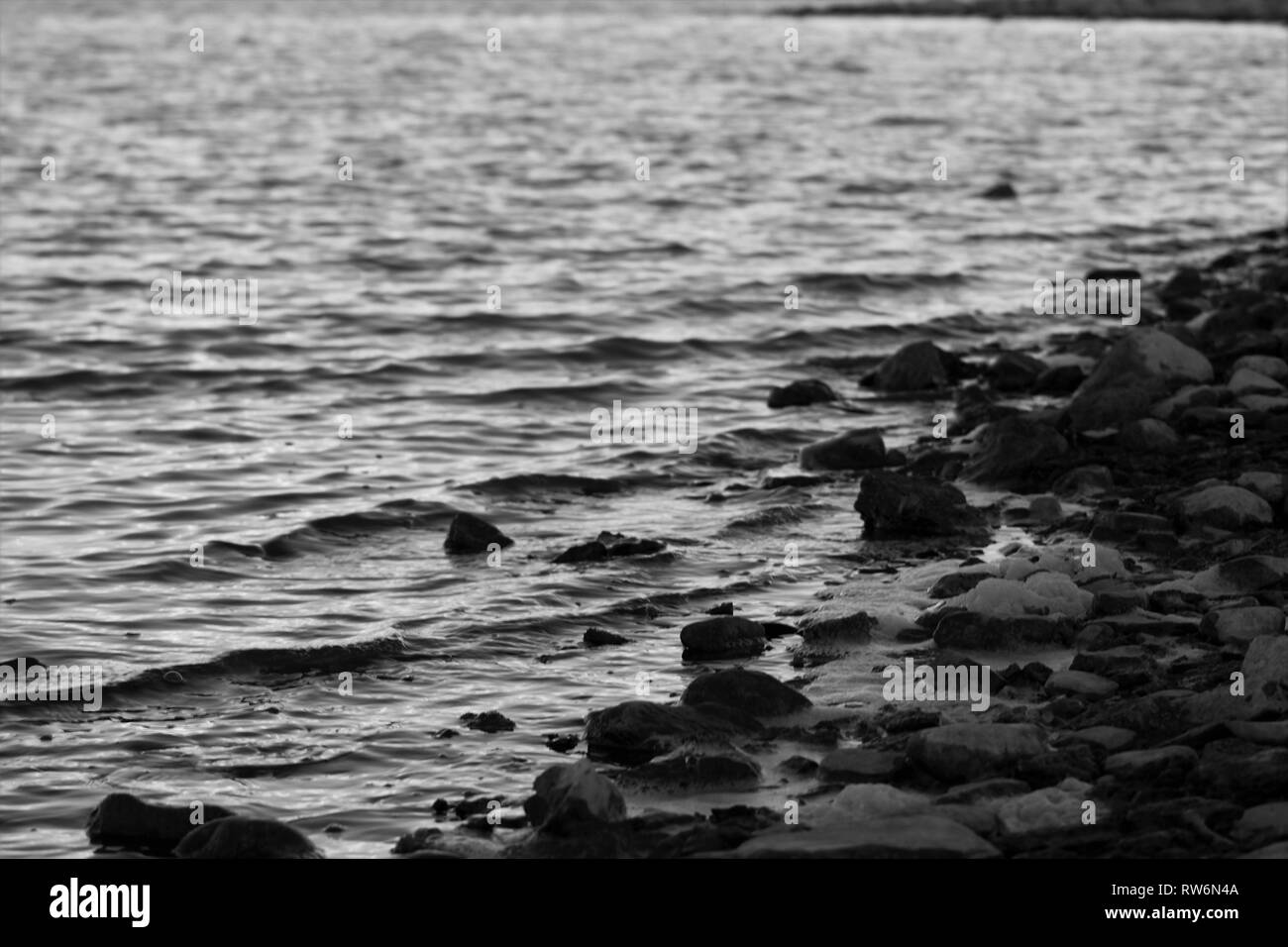 Black and White Waves hitting up Against Rocks Stock Photo - Alamy