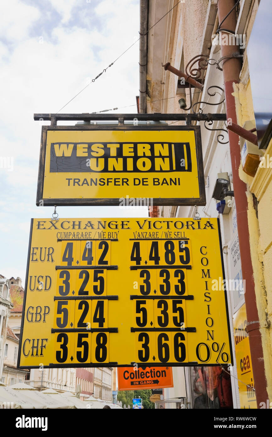 Yellow and black Western Union and Exchange Victoria foreign exchange business signs, Brasov, Romania, Eastern Europe Stock Photo