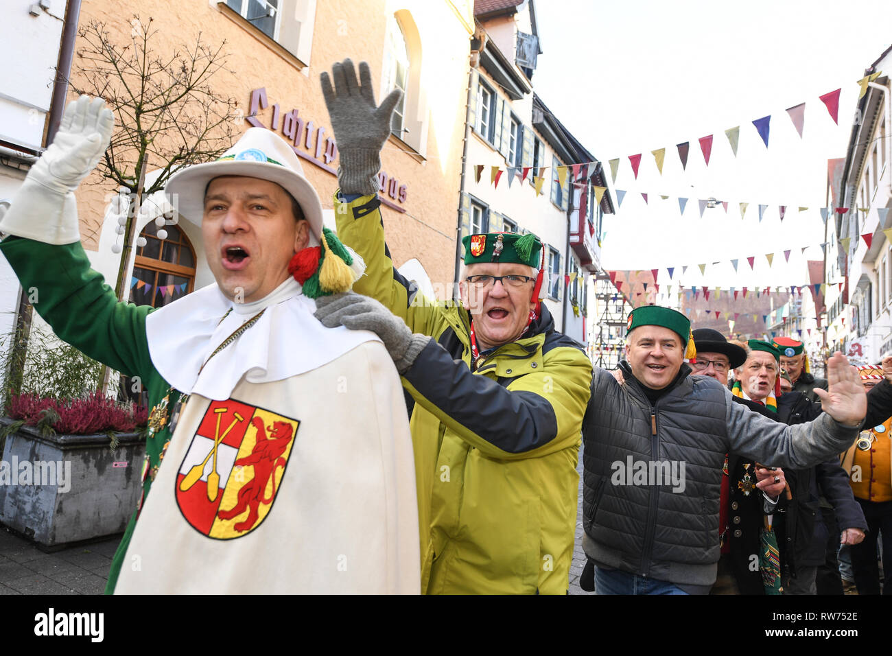 Riedlingen, Germany. 05th Mar, 2019. Winfried Kretschmann (Bündnis 90/Die Grünen, 2nd from left), Minister President of Baden-Würtemberg, is going through the city in a foolish parade on Tuesday at the carnival. Around 300 fools of the fool guild Gole 1865 take part in cigar smoking, the 190th Froschkuttel meal and the subsequent slide out of the town hall and later want to gamble through the town. Froschkuttel is a Riedlinger speciality. These are cut beef gizzards pickled in vinegar. Credit: Felix Kästle/dpa/Alamy Live News Stock Photo