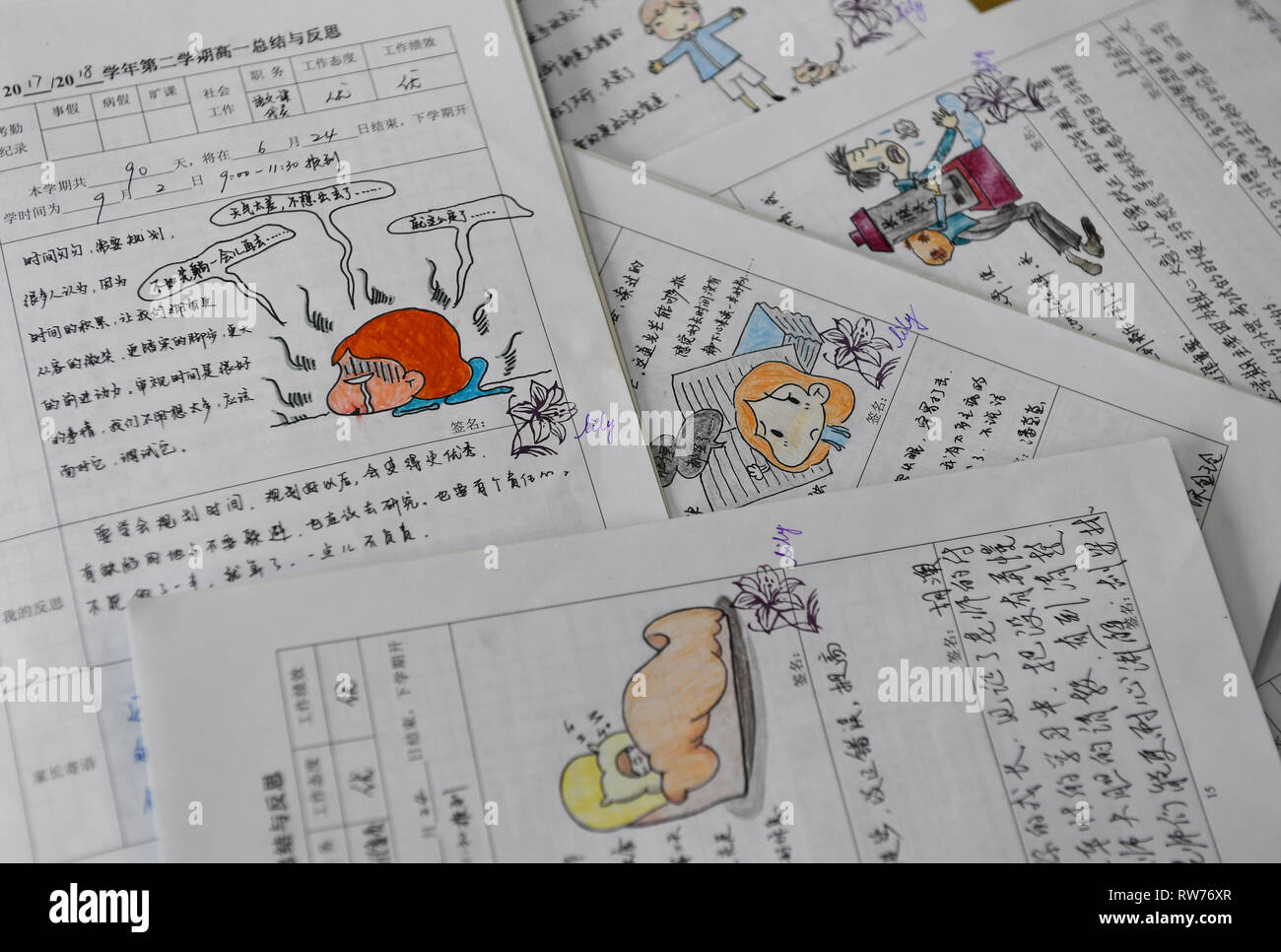 (190305) -- NANJING, March 5, 2019 (Xinhua) -- Comments with hand-drawn comics made by Yu Xiaolan are seen on student assignments at the Nanjing School for the Deaf in Nanjing, capital of east China's Jiangsu Province, March 4, 2019. Having spent 17 years with hearing-impaired students at the Nanjing School for the Deaf, Yu Xiaolan has never regretted her choice as a teacher here.     'I still remember the day when I came to the campuse for the job interview,' said Yu, 'I could see students running on the playground, just like the normal kids of other schools, but I couldn't hear even a small  Stock Photo