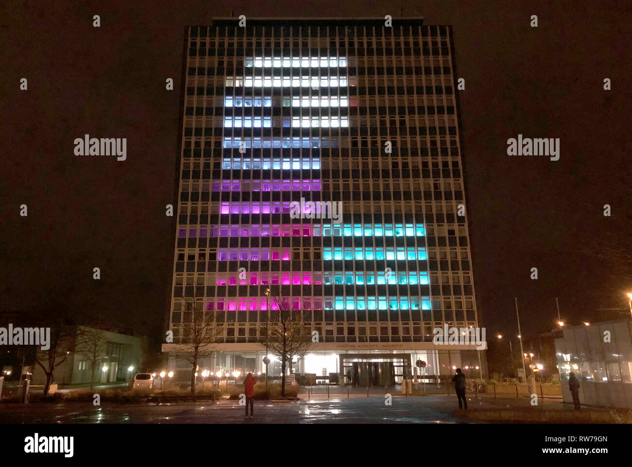 05 March 2019, Schleswig-Holstein, Kiel: Different colours shine in the windows of the high-rise building of the Christian-Albrechts-University. Computer science students from Kiel have programmed their own implementations of a puzzle game, which they play on the facade of the university high-rise as part of the 'Project Lighthouse'. 56,448 LEDs on the 392 windows transform the facade of the university high-rise into a giant matte pane with a diagonal of a good 43 metres. Photo: Andre Klohn/dpa Stock Photo