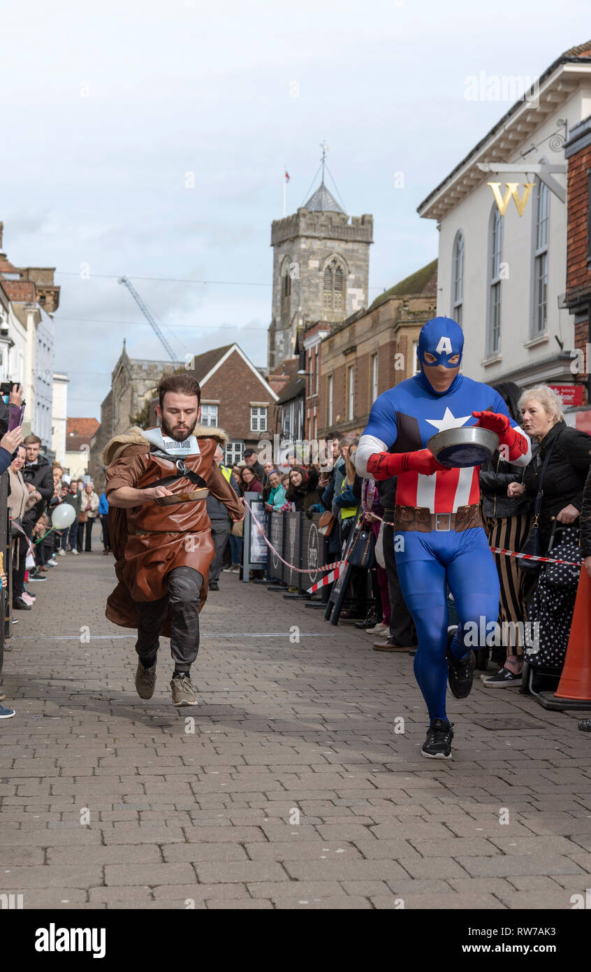 Salisbury, Wiltshire, UK. 5th Mar, 2019. Competitors competing in the annual pancake race on High Street, Salisbury. The event is organised by St Thomas's Church and the Trussell Trust. Stock Photo