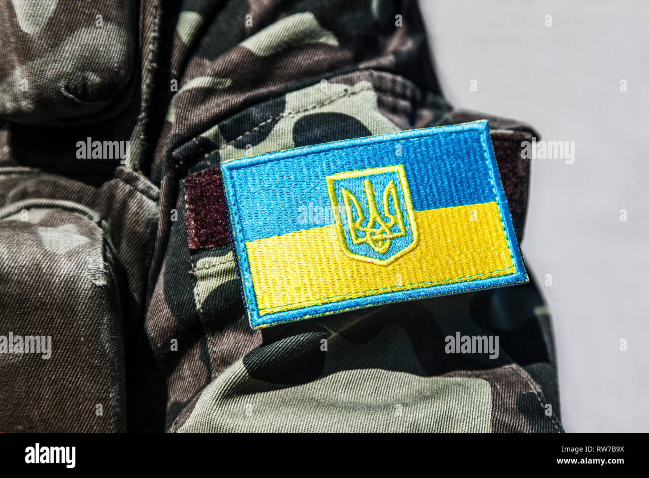 Military badge of Ukrainian Army with trident and yellow-blue flag. Stock Photo