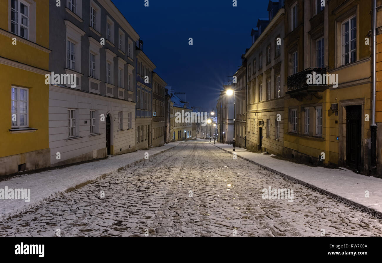 The snow-covered street of the old city in Warsaw during the winter night Stock Photo