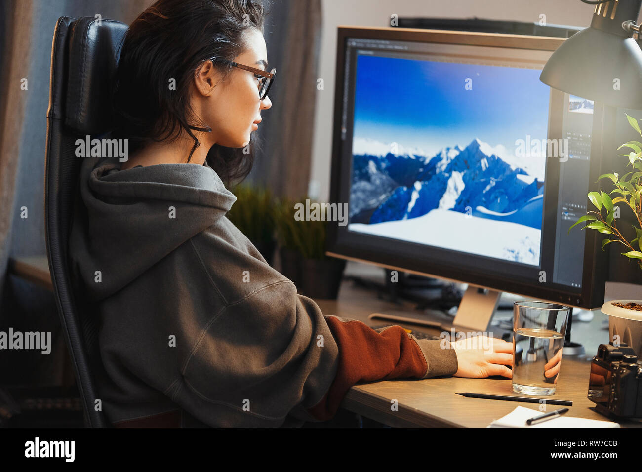 Young attractive woman freelancer designer working on pc at home. Concept of freedom and creativity. Home office. Casual dress. Stock Photo