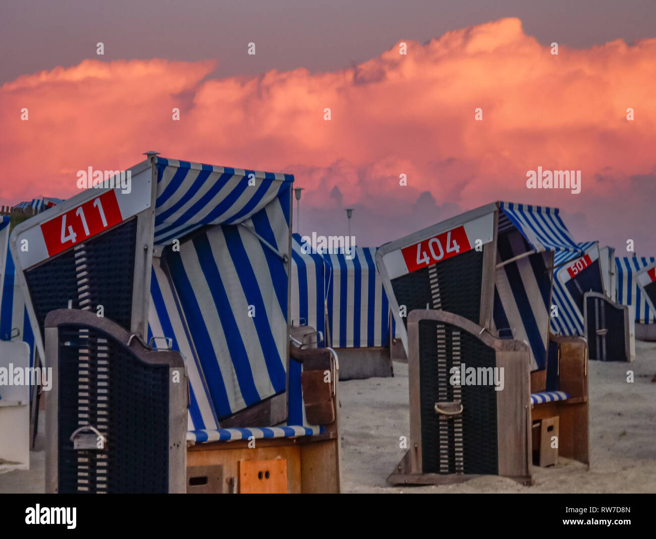two beach chairs in burning sky sunset on island Norderney, germany Stock Photo