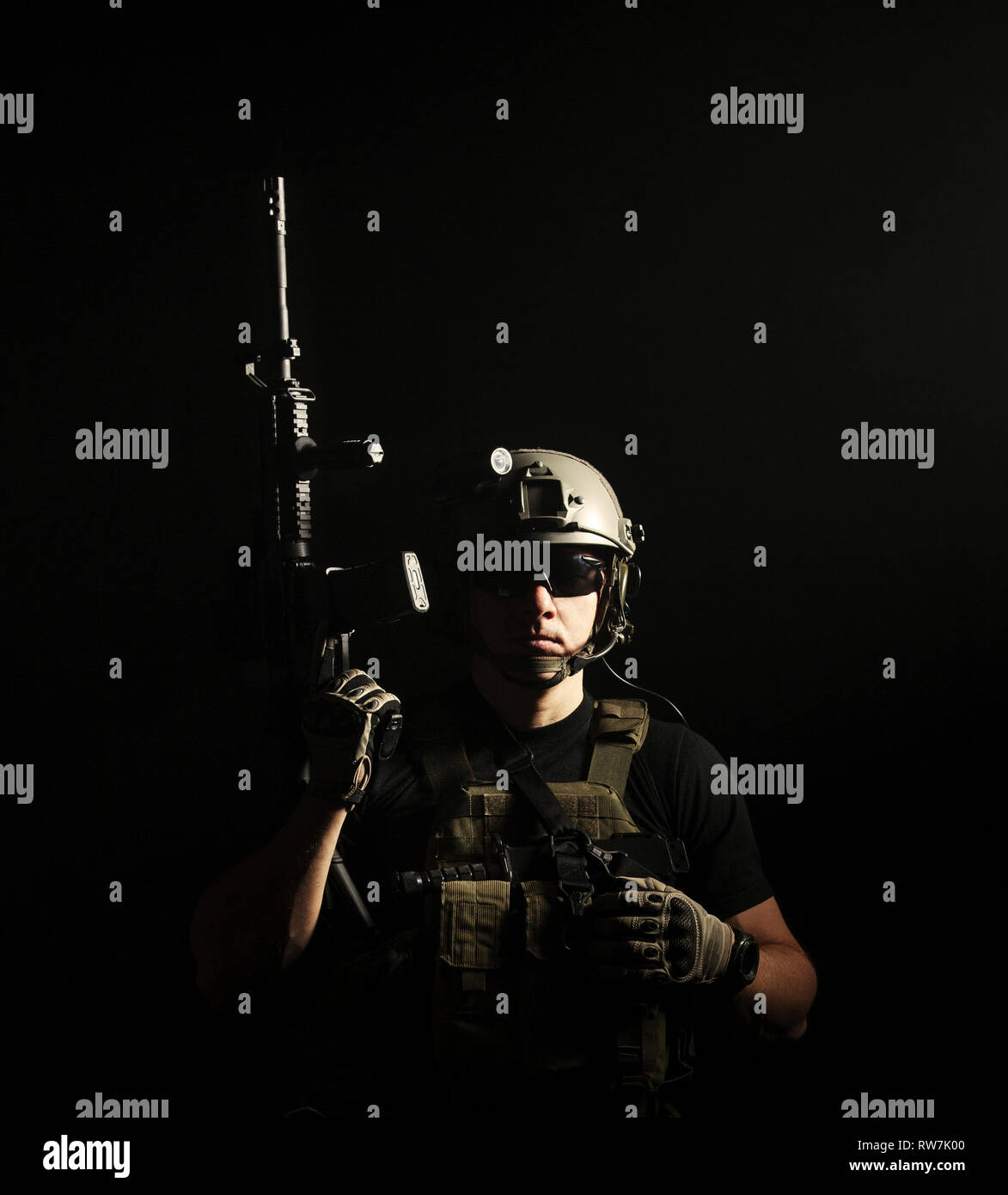 Private military contractor PMC with assault rifle on dark background. Stock Photo