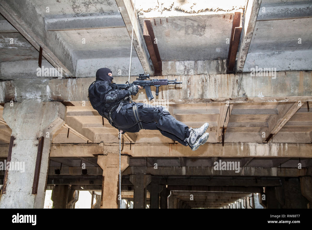 Special forces operator during assault rappelling with weapons