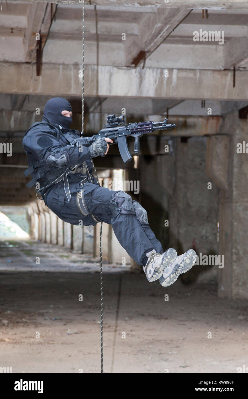 Special forces operator during assault rappelling with weapons