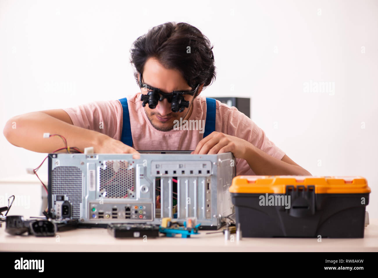 Young male contractor repairing computer Stock Photo