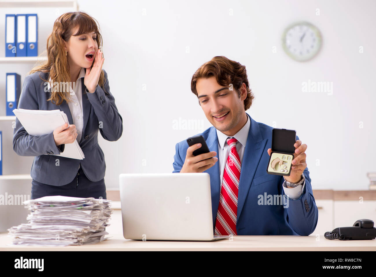 Deaf employee using hearing aid talking to boss Stock Photo