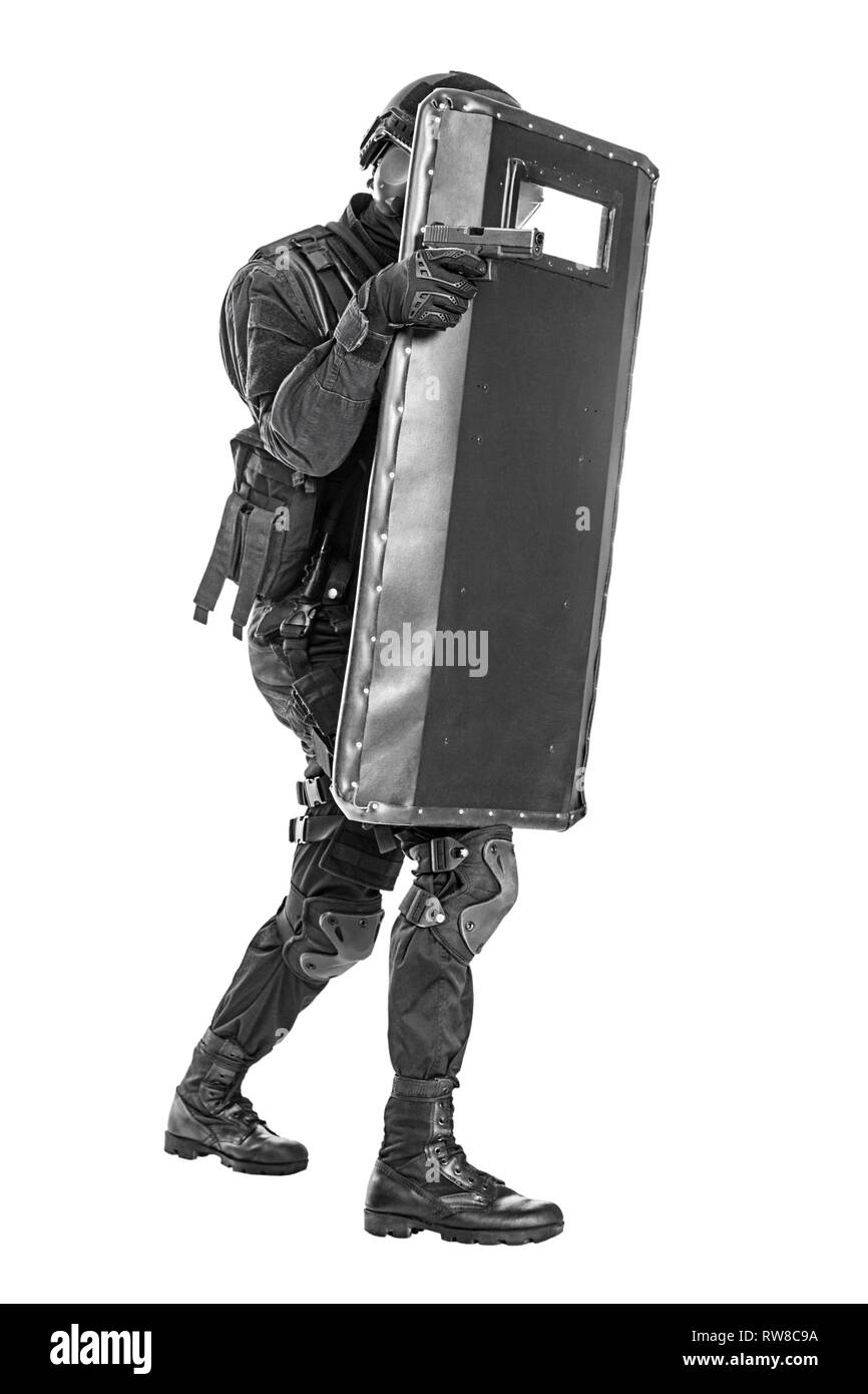 Studio shot of SWAT police special forces with pistol behind ballistic shield. Stock Photo