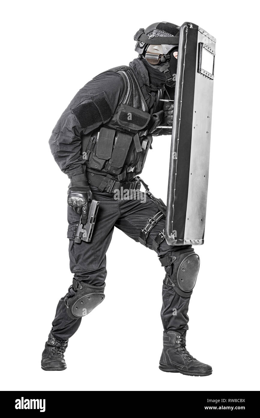 Studio shot of SWAT police special forces with pistol hiding behind ballistic shield. Stock Photo