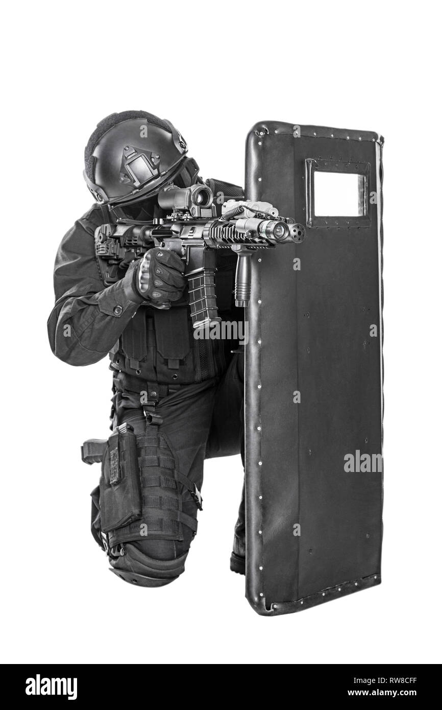 Studio shot of SWAT police special forces with rifle hiding behind  ballistic shield Stock Photo - Alamy